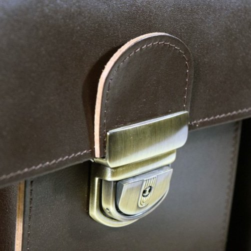 3. Close-up of brass clasp on Papillon Briefcase No. 35, highlighting craftsmanship and leather detail