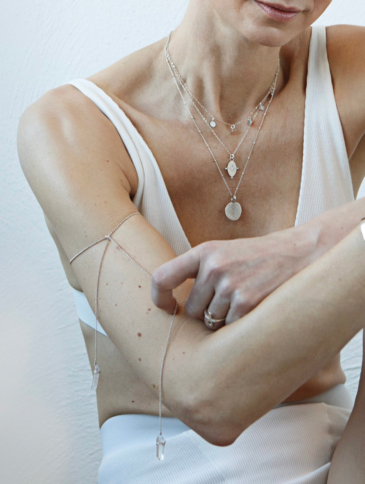 1. Women's layered silver necklaces including Stargazer Choker by New Vintage by Kriss, styled with a white top