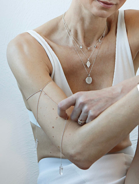 1. Women's layered silver necklaces including Stargazer Choker by New Vintage by Kriss, styled with a white top