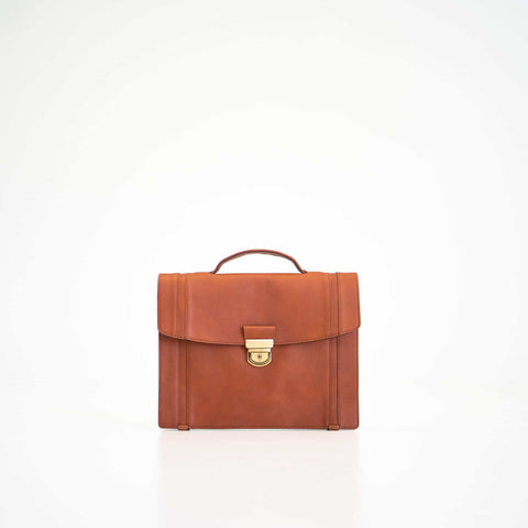 4. Front view of Papillon Briefcase No. 21 in cognac leather, showcasing handle and clasp, studio setting