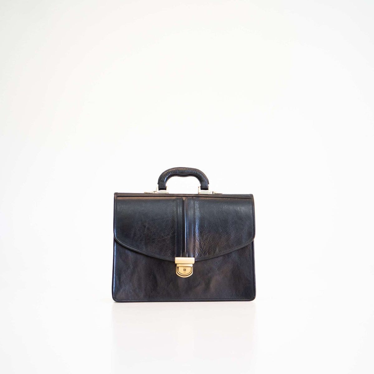 3. Front view of Papillon Briefcase No. 20 in black leather, highlighting gold clasp and handle
