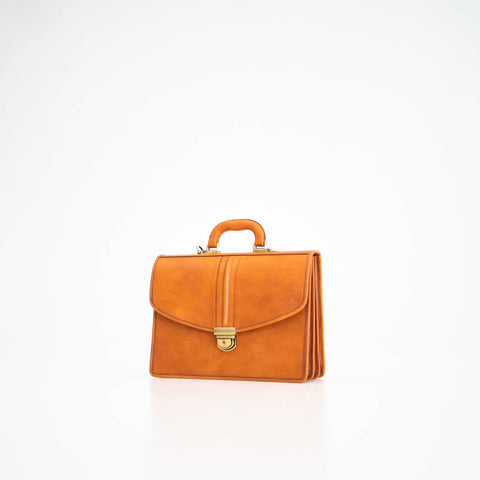 1. Papillon Briefcase No. 20 in cognac leather, shown in studio setting with front view
