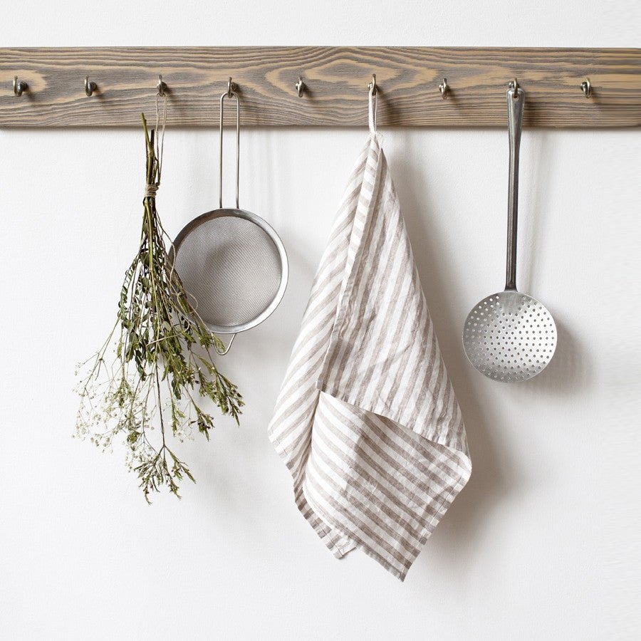 4. Striped linen kitchen towel hanging on wooden rack with kitchen utensils and dried flowers