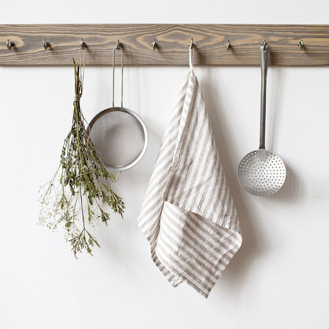 4. Striped linen kitchen towel hanging on wooden rack with kitchen utensils and dried flowers