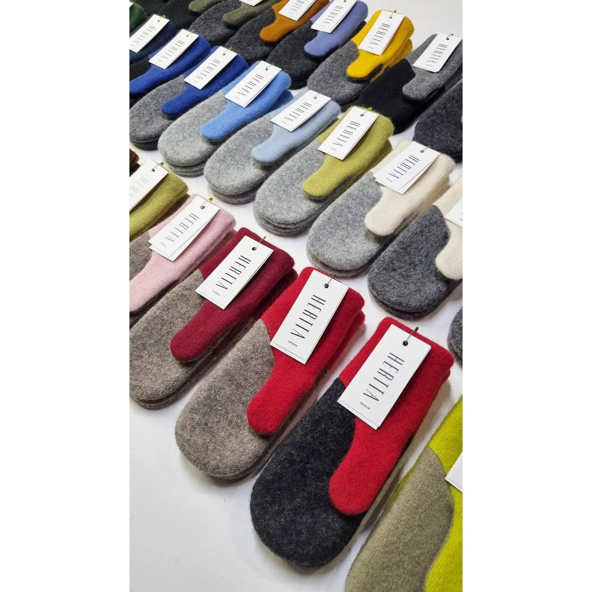 2. Assorted HERTTA felted wool mittens in various colors, displayed with tags