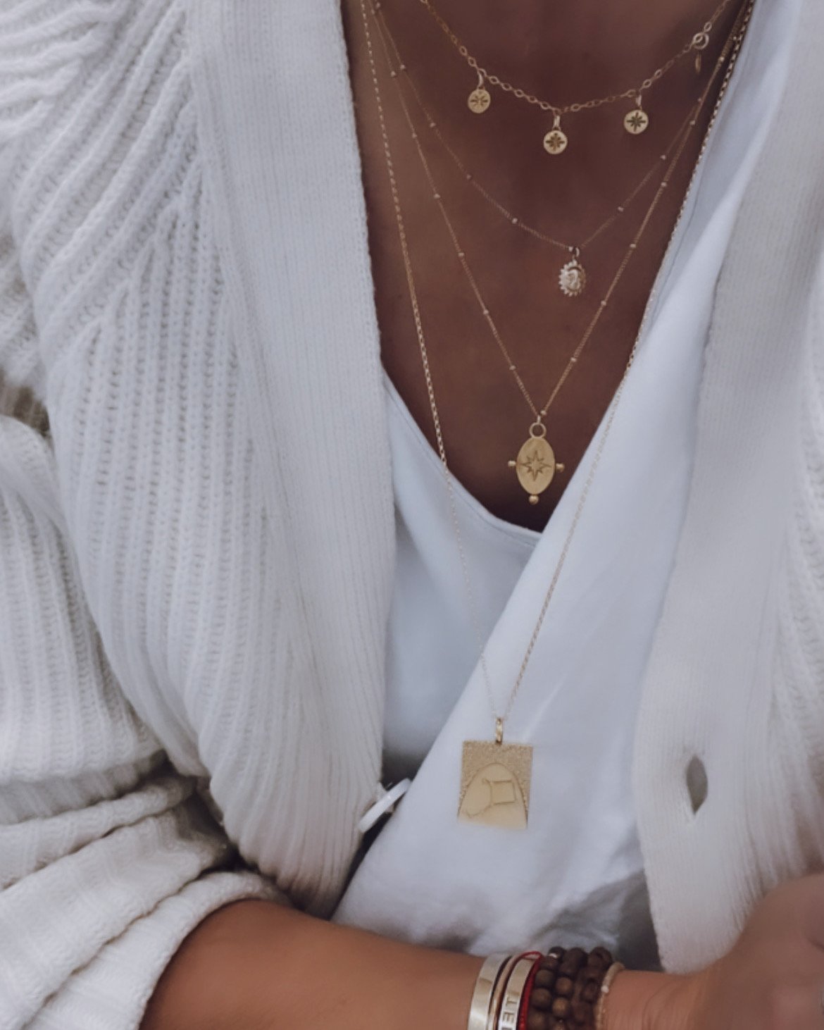 3. Close-up of layered gold necklaces including Stargazer Choker by New Vintage by Kriss, worn with white outfit