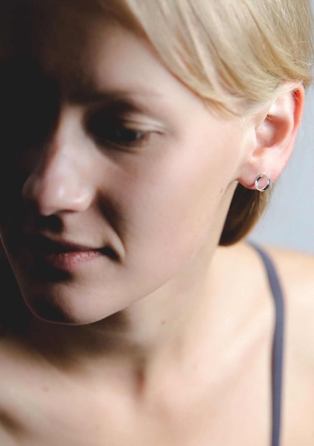 1. Woman wearing Maarja Palu CIRCLE earrings in silver, showcasing minimalist design