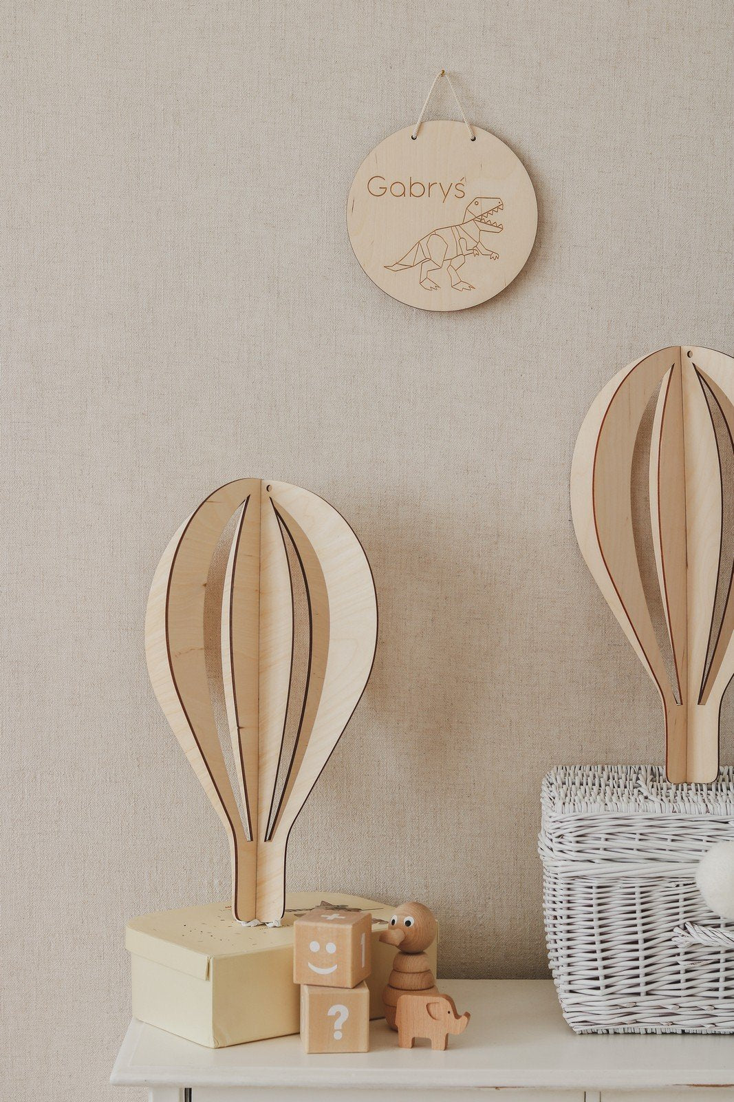 3. Two birch plywood hot air balloon decorations on cabinet with wicker basket and personalized wooden sign