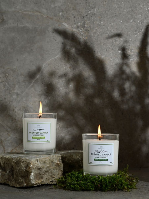 2. Magrada Organic Cosmetics Moss&Grass and Lemongrass scented candles lit on stone surface, highlighting warm ambiance