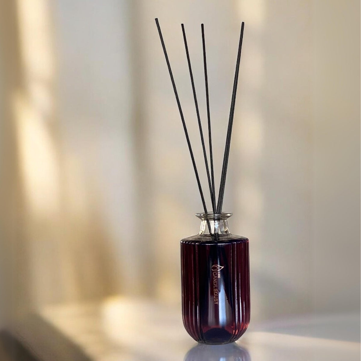 1. Luxurious Rosso room diffuser by Candledust with fiberstick reeds on a table, creating a romantic ambiance