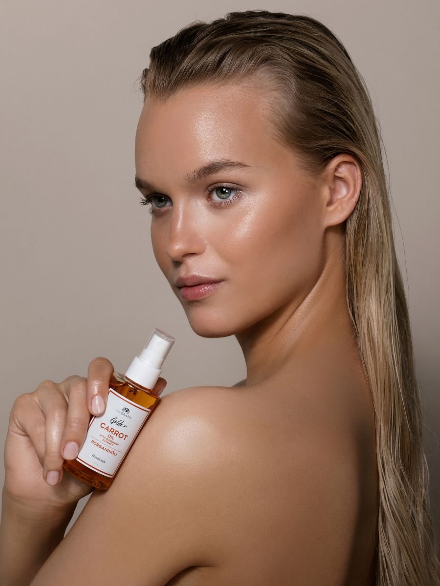 1. Woman holding Magrada Organic Cosmetics Carrot Oil with Rosemary Extract, showcasing radiant skin