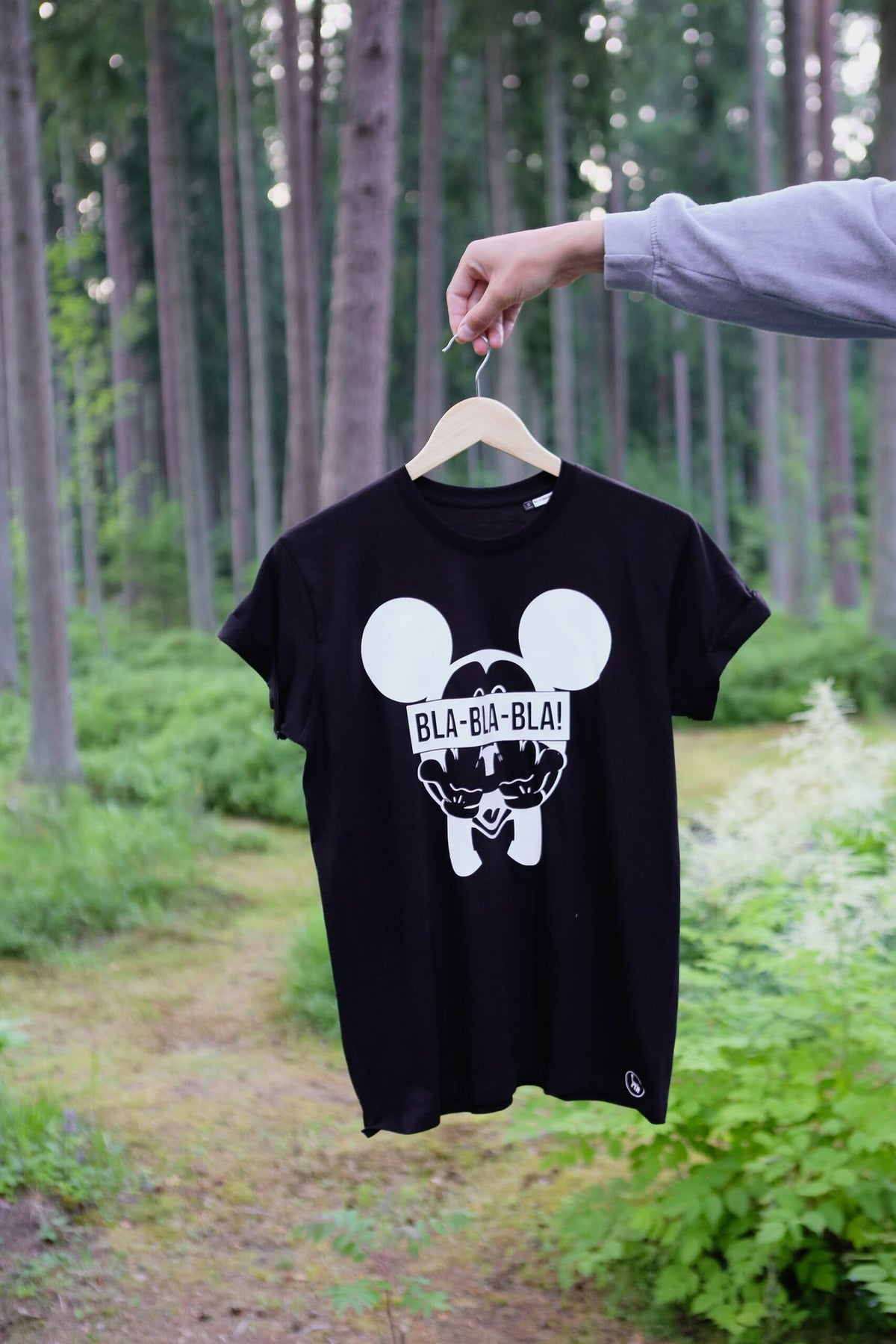 1. Black Giraffe Brand Blablabla Mickey T-shirt in black with 'BLA-BLA-BLA!' text and Mickey graphic, shown in a forest setting