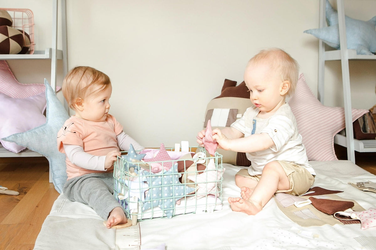 8. Two babies playing with starlet toys in a room with pastel decor