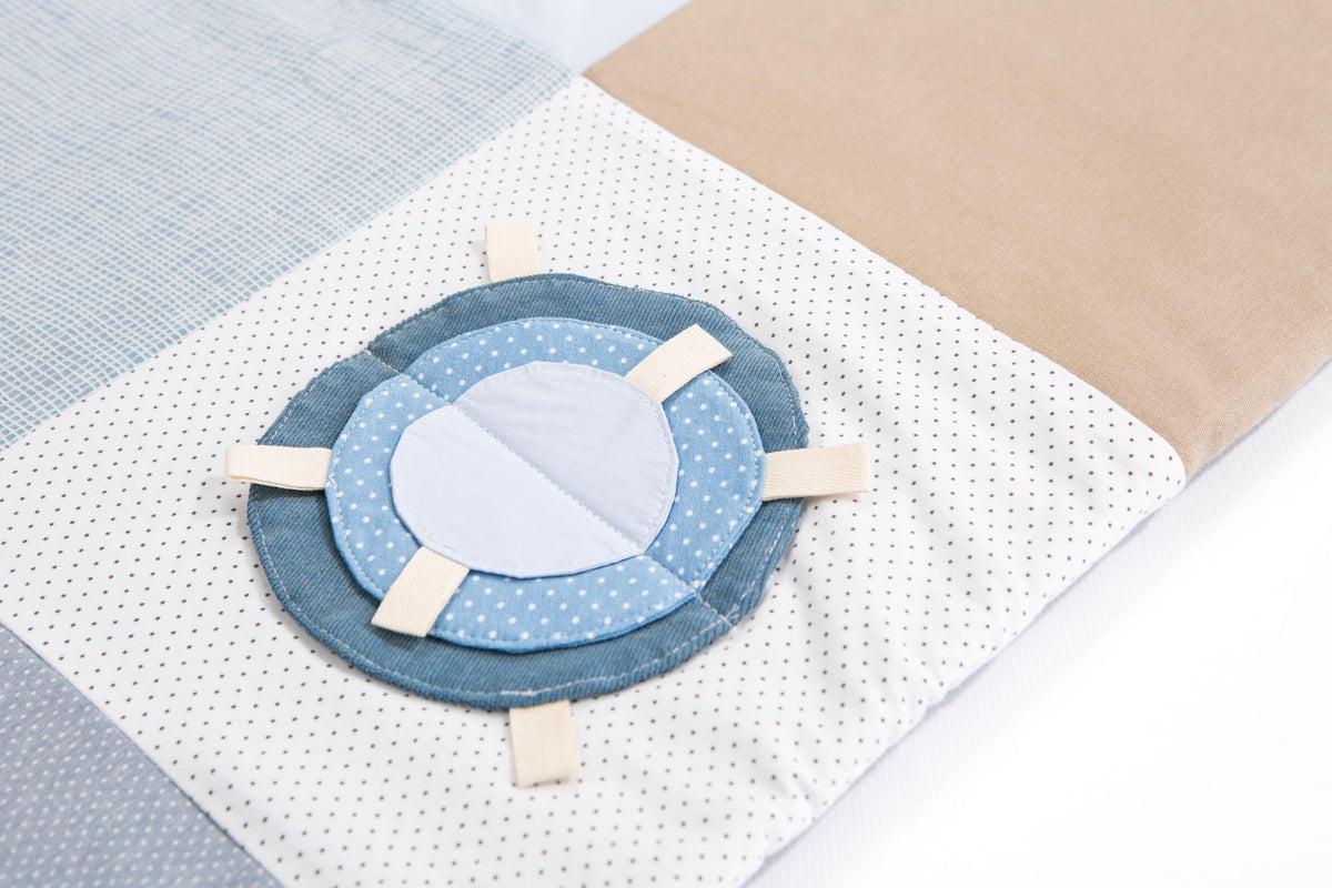 3. Close-up of circular blue and white fabric detail on Karloova activity mat