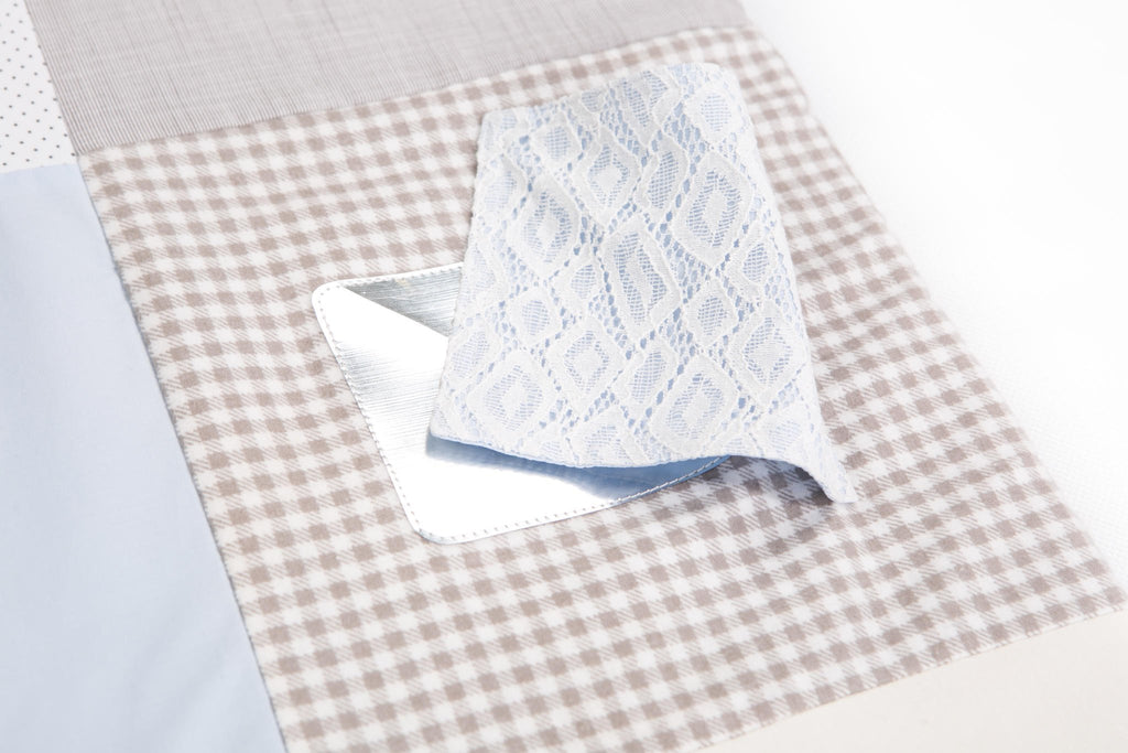 3. Detail of Karloova activity mat with blue lace fabric flap over checkered pattern