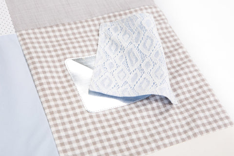 3. Detail of Karloova activity mat with blue lace fabric flap over checkered pattern