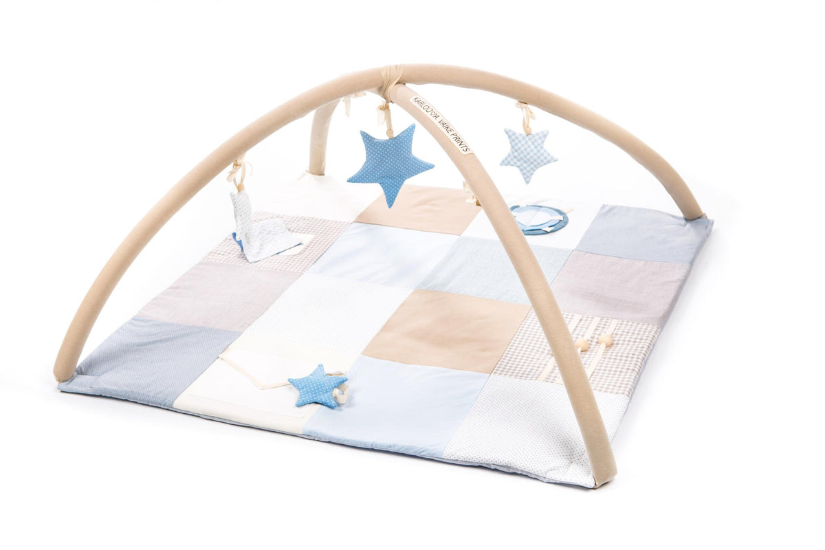1. Karloova baby activity mat with blue and beige patchwork design, featuring activity arches and hanging star toys in a studio setting