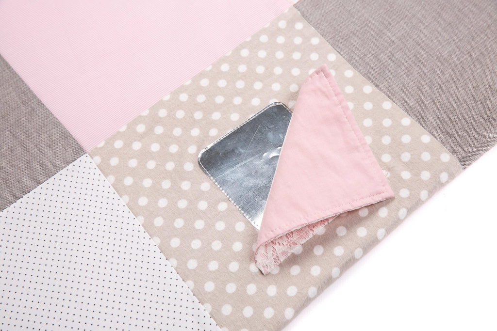 3. Close-up of pink fabric flap revealing shiny surface on activity mat