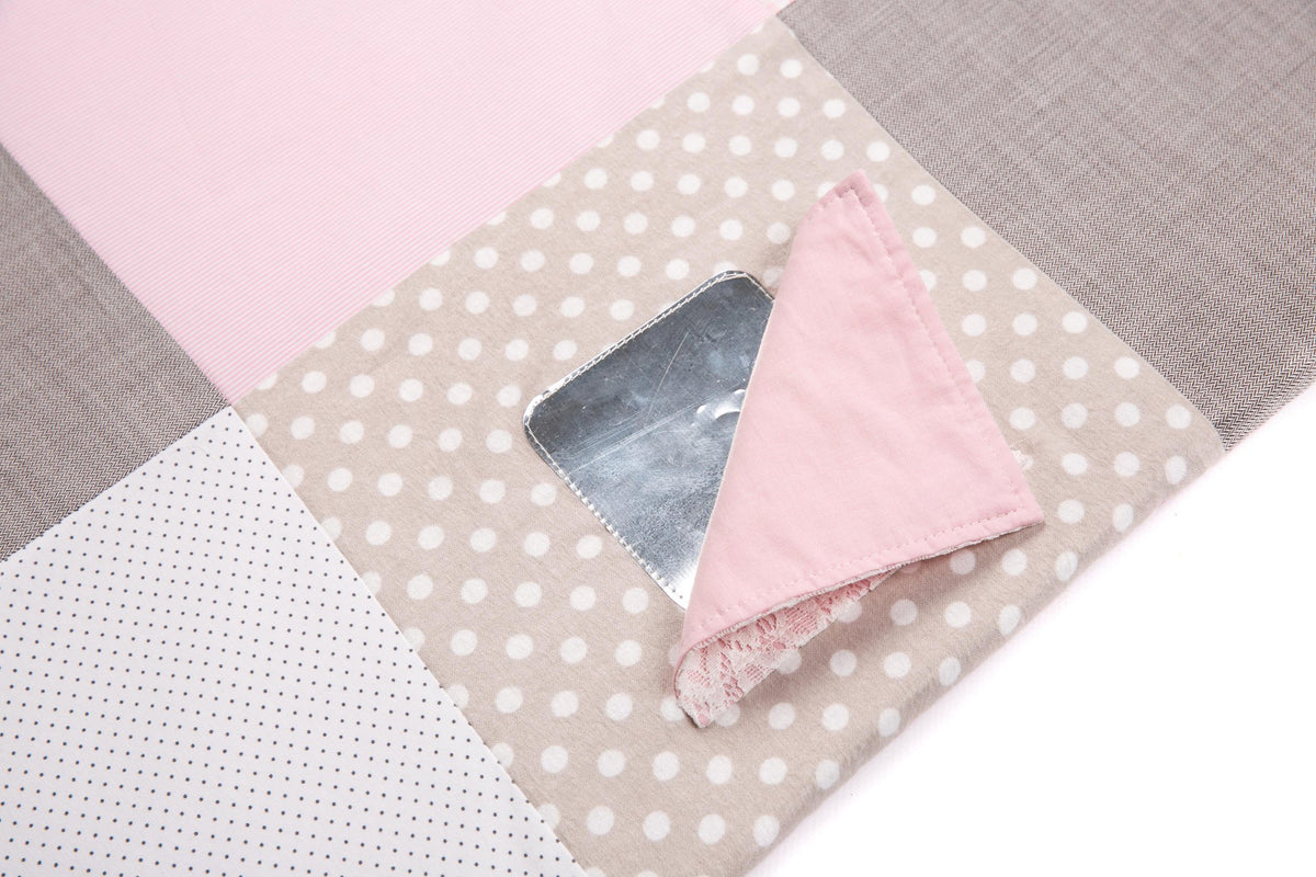 3. Close-up of pink fabric flap revealing shiny surface on activity mat