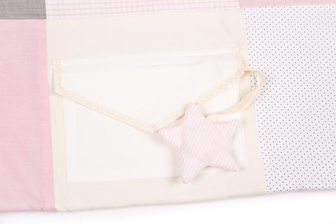 3. Close-up of pink striped star toy attached to envelope pocket on activity mat