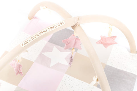 2. Close-up of Karloova activity mat showing pink star toys and brand text on arches
