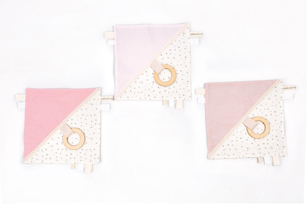 4. Three Karloova comfort blankets with pink and white fabric, wooden hoops, and star patterns on white background