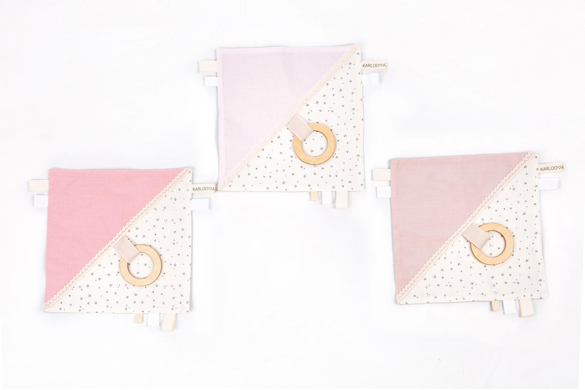 4. Three Karloova comfort blankets with pink and white fabric, wooden hoops, and star patterns on white background