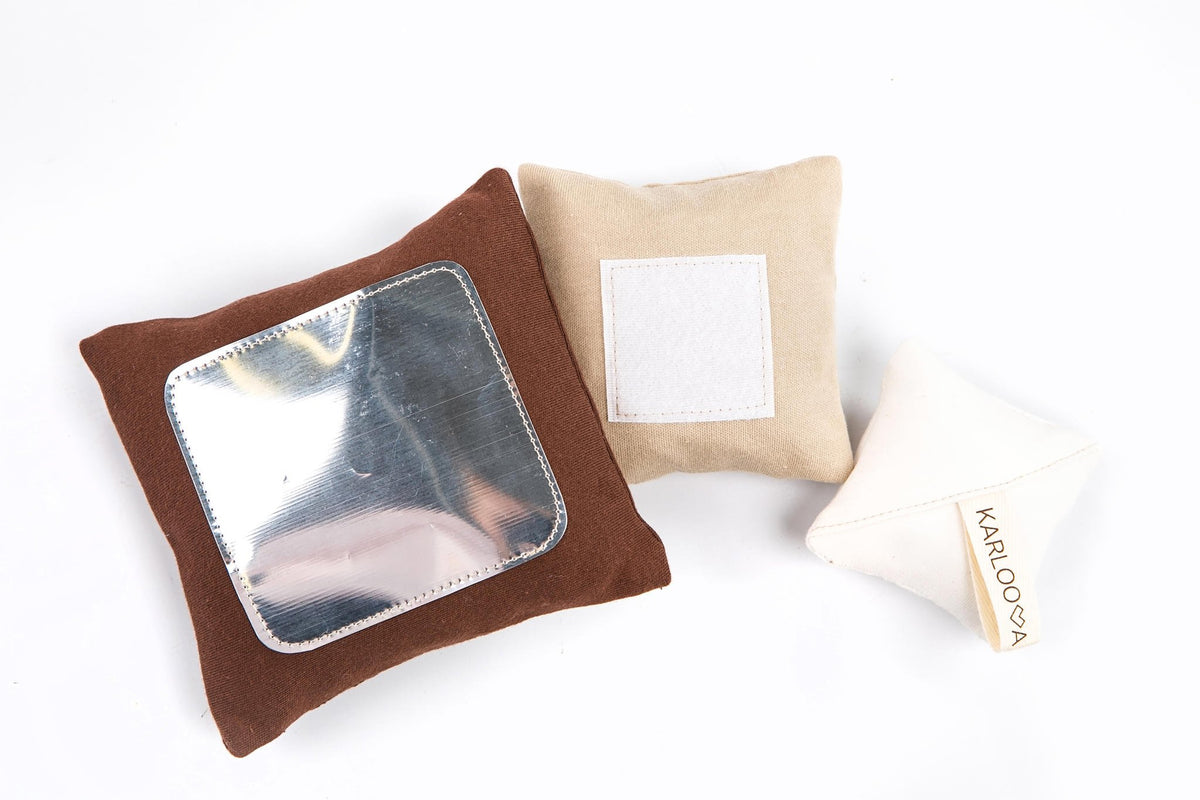 2. Close-up of Karloova Pillow Heap pillows with mirror and brand label on white background