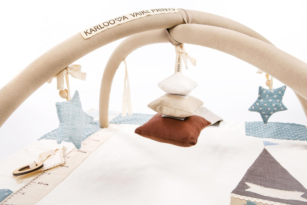 1. Karloova Pillow Heap hanging from activity arch with star decorations in nursery setting