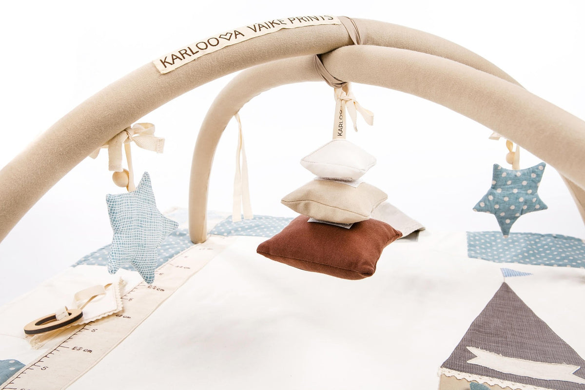 1. Karloova Pillow Heap hanging from activity arch with star decorations in nursery setting