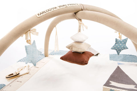 1. Karloova Pillow Heap hanging from activity arch with star decorations in nursery setting