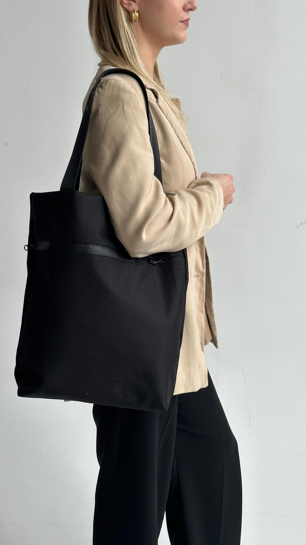 7. Woman in beige jacket carrying Nordhale VIK Tote Bag, side profile