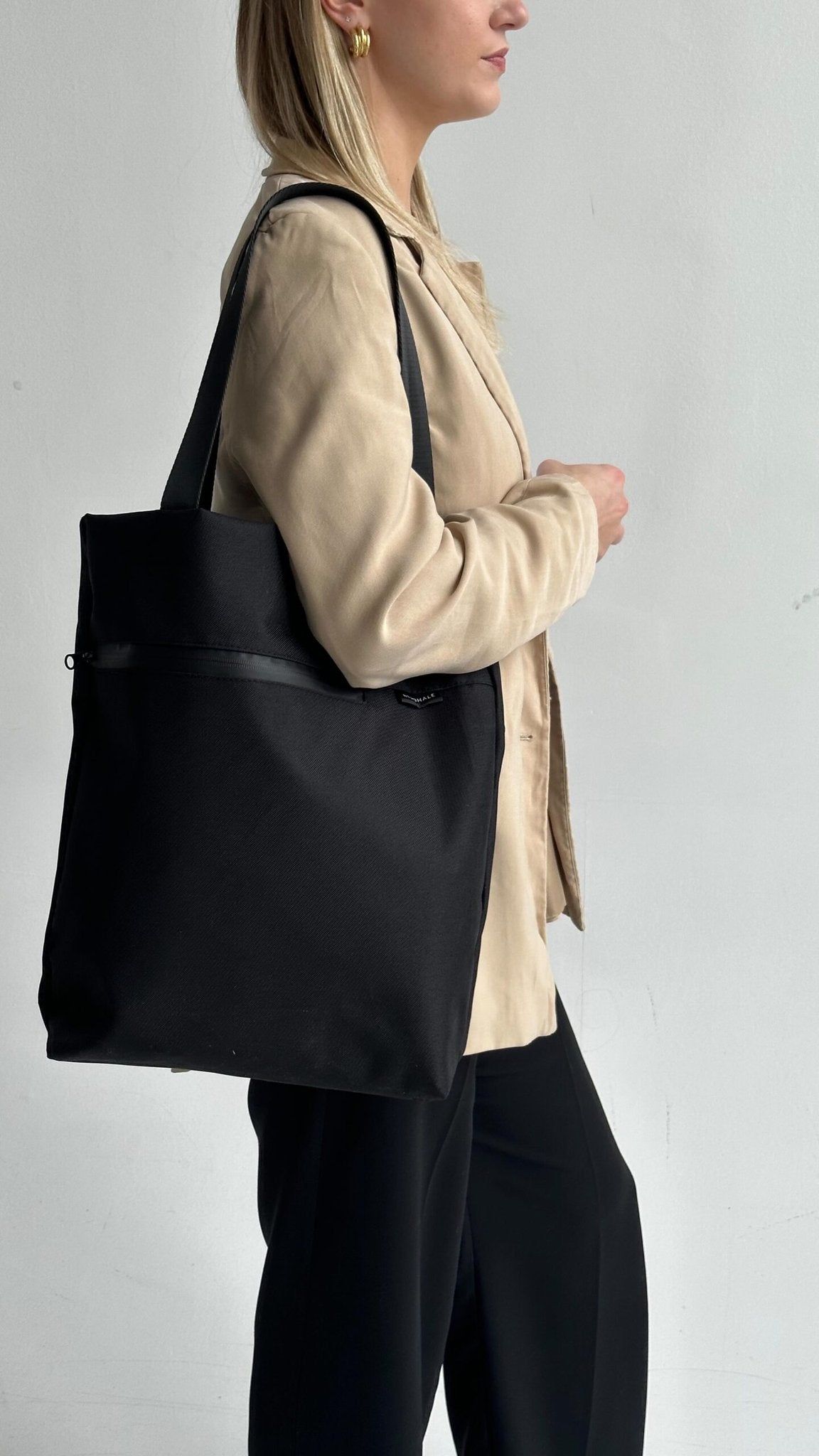 7. Woman in beige jacket carrying Nordhale VIK Tote Bag, side profile
