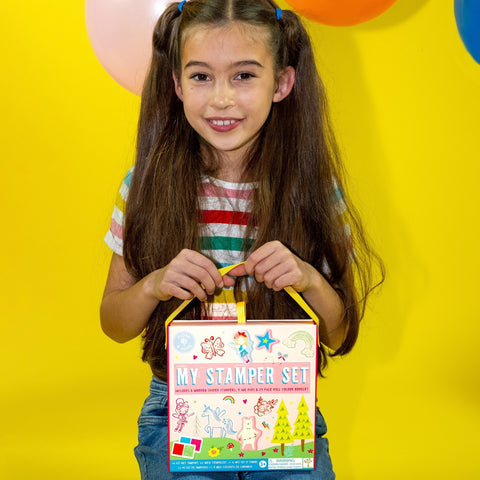1. Young girl holding Floss & Rock My Stamper Set with colorful balloons in background