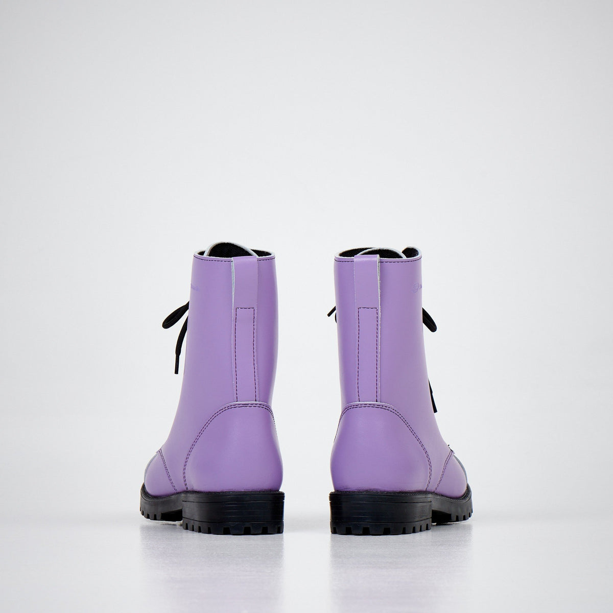 2. Back view of unisex purple leather boots with black laces and rugged sole on white background