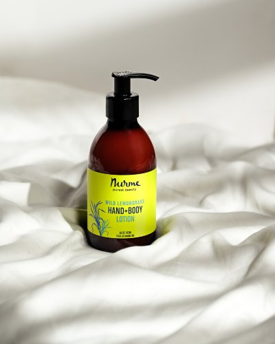 2. Nurme Wild Lemongrass Hand and Body Lotion bottle on white fabric, showcasing packaging