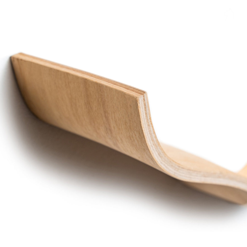 3. Close-up of curved edge of wooden toilet paper holder showing craftsmanship