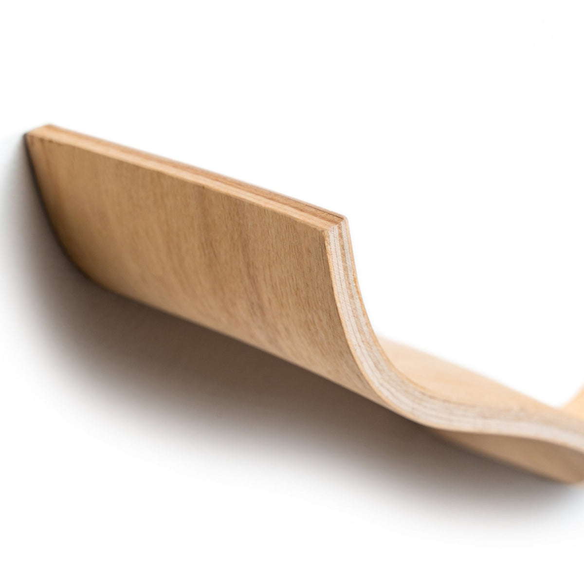 3. Close-up of curved edge of wooden toilet paper holder showing craftsmanship