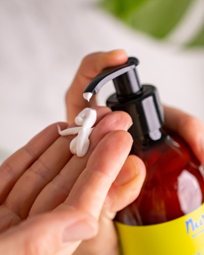 1. Close-up of Nurme Wild Lemongrass Hand and Body Lotion being dispensed from pump bottle