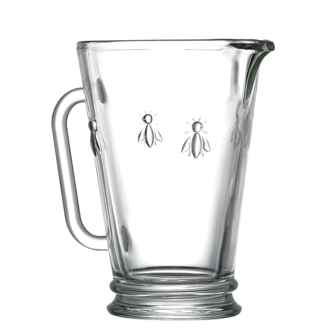 2. Transparent glass jug with embossed bee design, featuring a sturdy handle and spout, from La Rochère's Abeille collection
