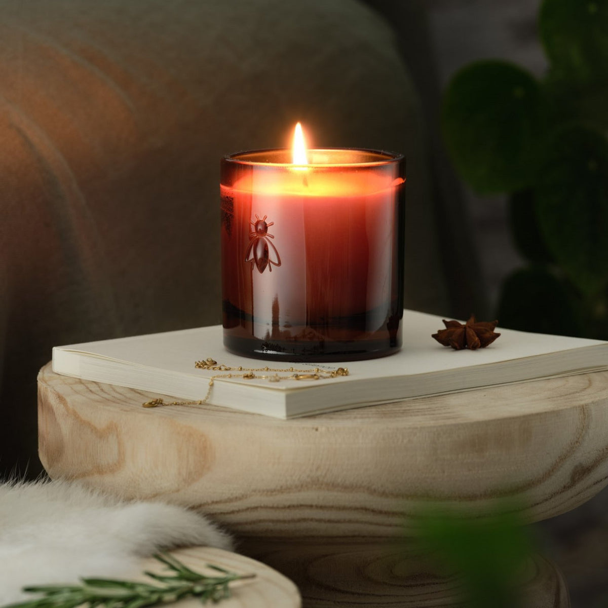 1. La Rochère Orange Blossom Bee Candle lit, creating a cozy atmosphere on a wooden table