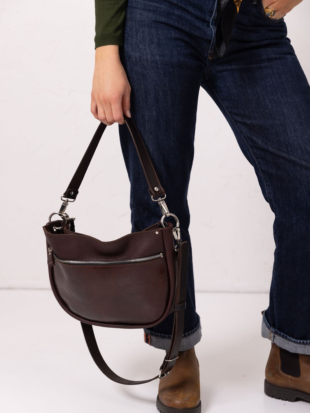 6. Close-up of woman holding TOKS VISOKS STELLA leather handbag in brown and cognac, highlighting leather texture