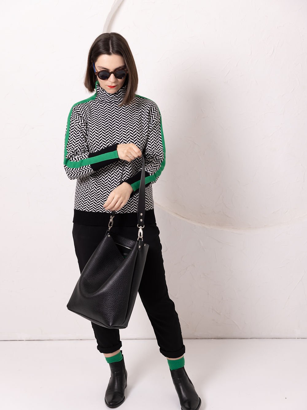 2. Woman wearing ADDISON Leather Tote in black, styled with patterned top and sunglasses