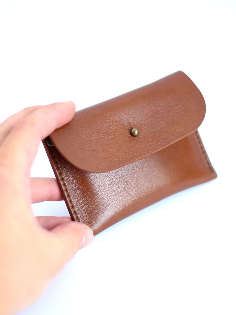 4. Hand holding TOKS VISOKS WEEKEND Wallet in Ginger, demonstrating size and recycled leather texture