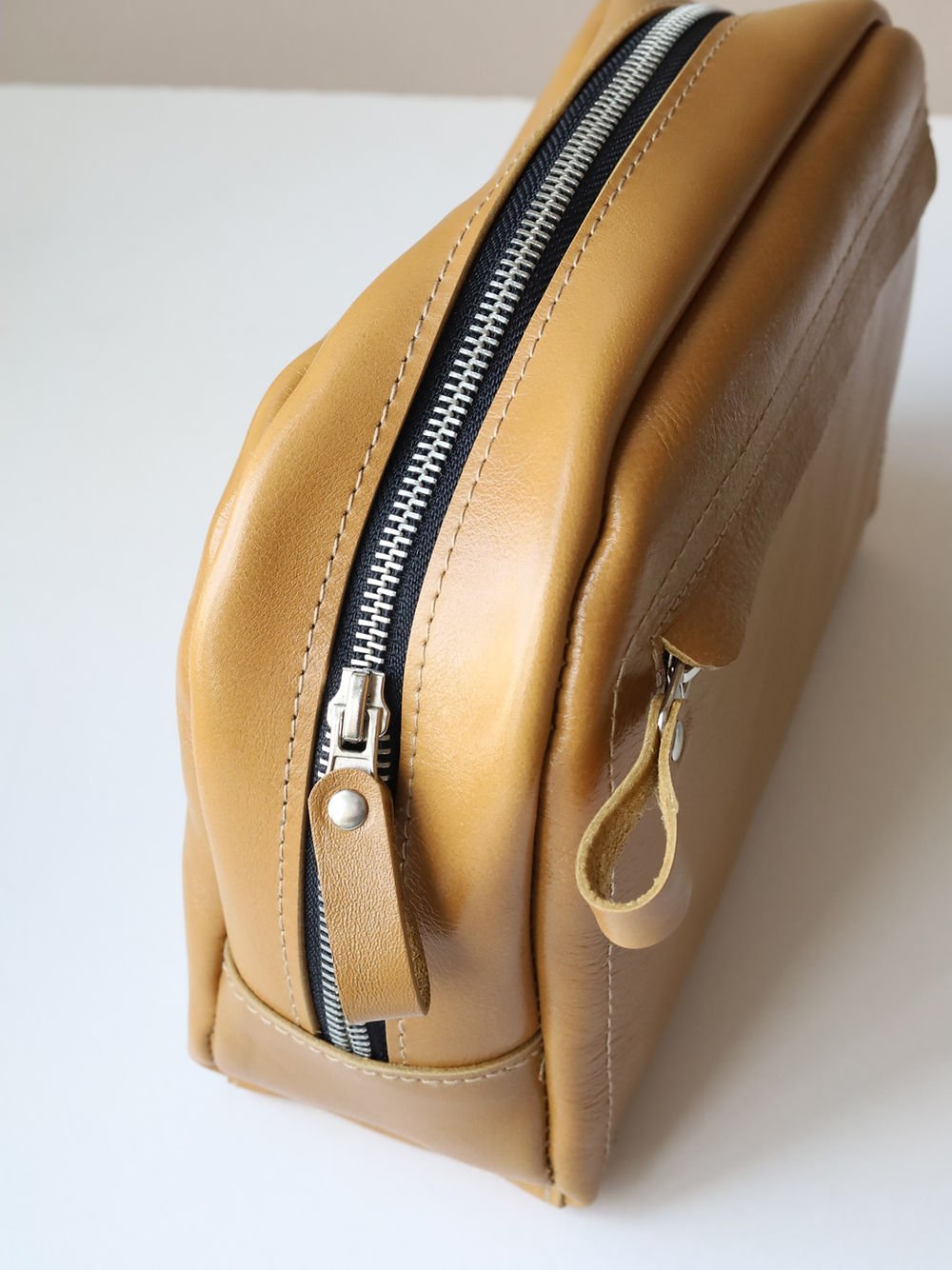 4. Studio shot of DOUGLAS Toiletry Bag in mustard highlighting zipper detail, TOKS VISOKS brand
