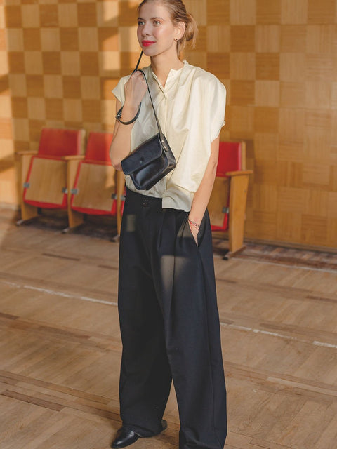 1. Women's black RUBY Purse by TOKS VISOKS worn crossbody in a stylish indoor setting