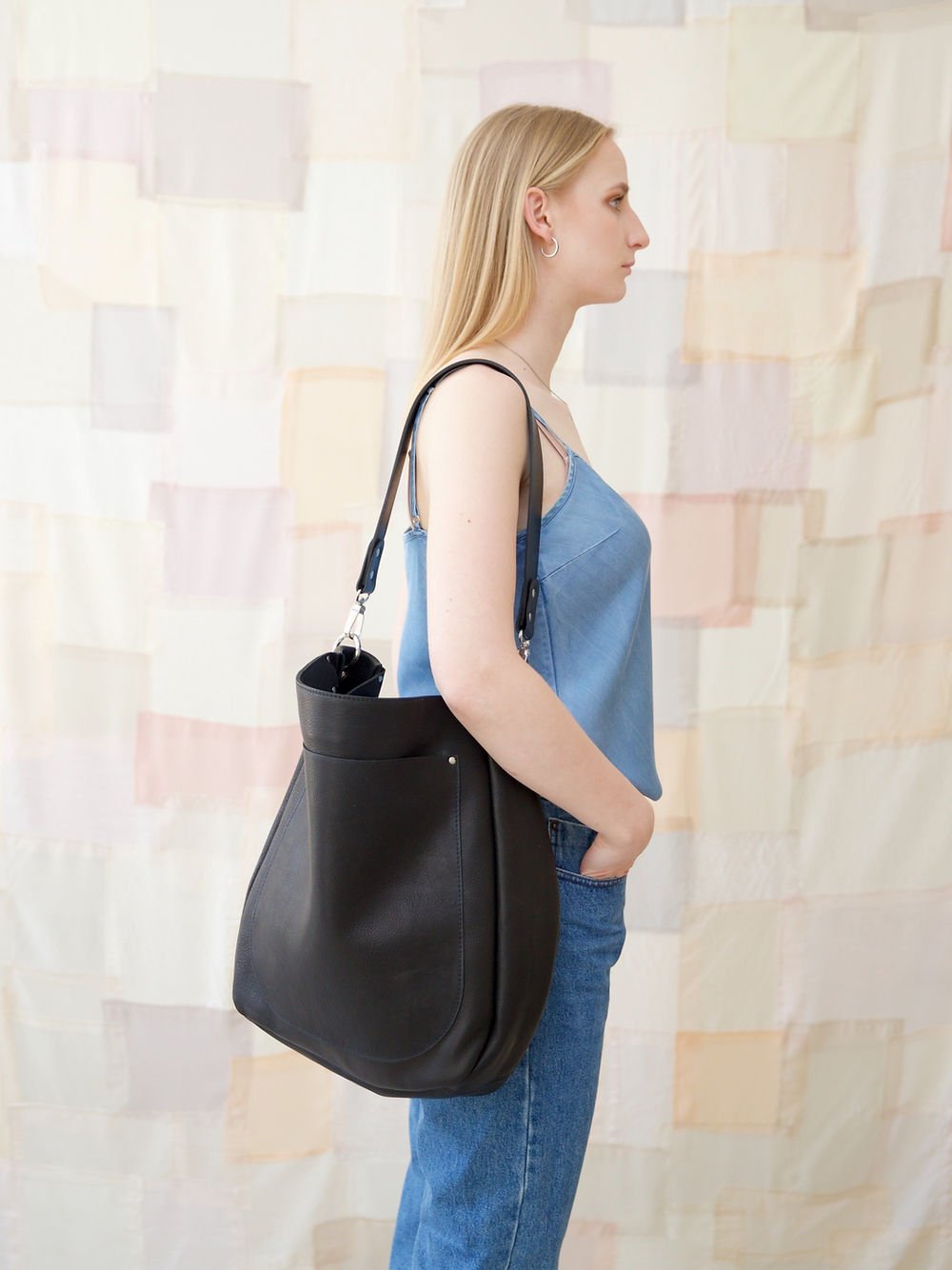 1. Women's LULU black handbag by TOKS VISOKS, worn over shoulder, showcasing spacious design and front pocket