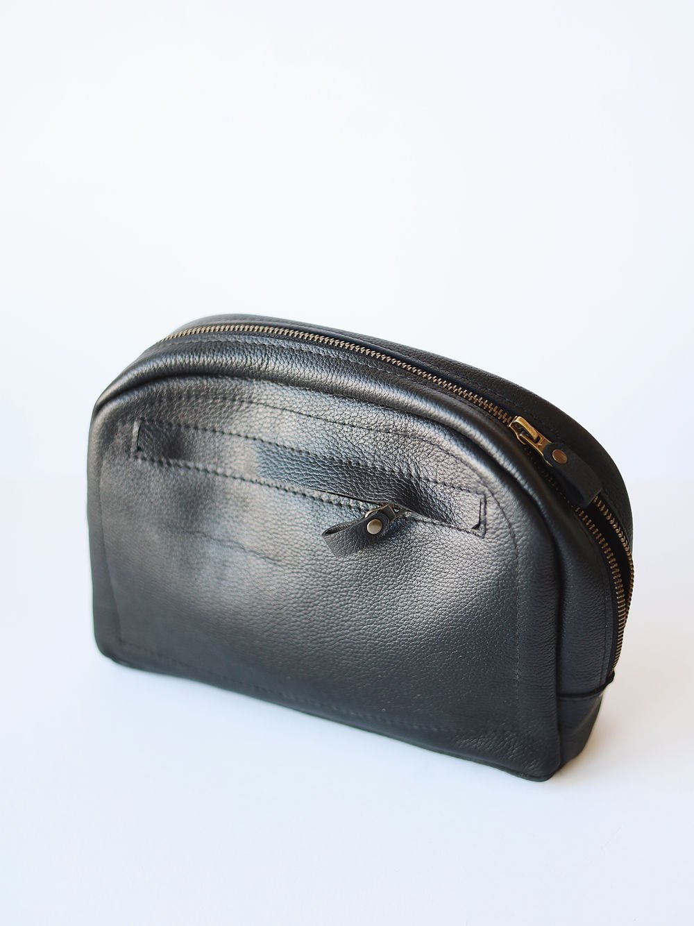 1. TOKS VISOKS black leather toiletry bag with front zipper pocket, shown in studio setting