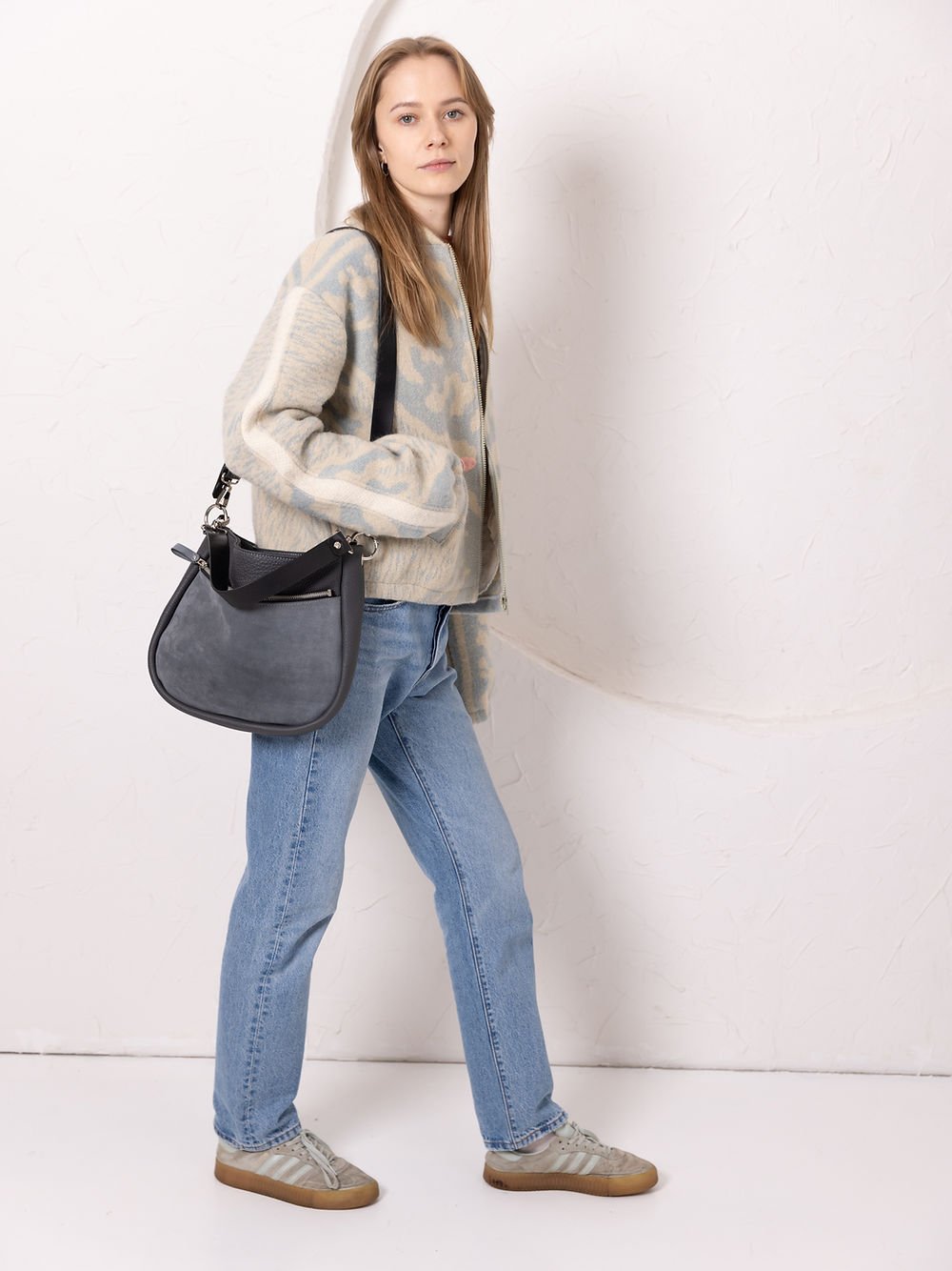6. Woman carrying TOKS VISOKS STELLA grey leather handbag with suede detail, styled with casual outfit in studio