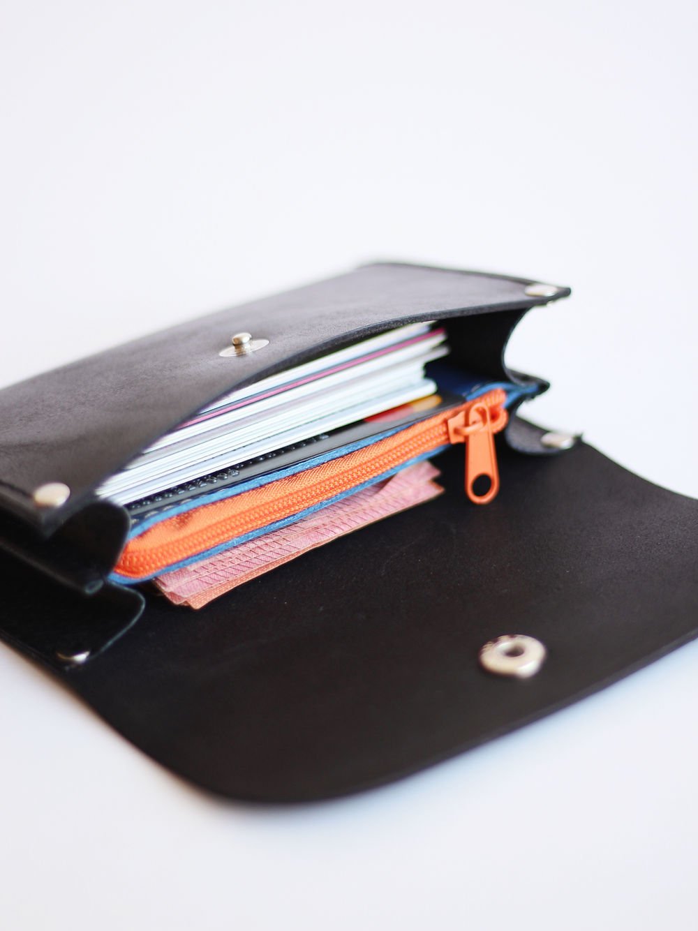 3. Open black FRIDAY Wallet by TOKS VISOKS displaying organized interior with cards and orange zippered coin pocket